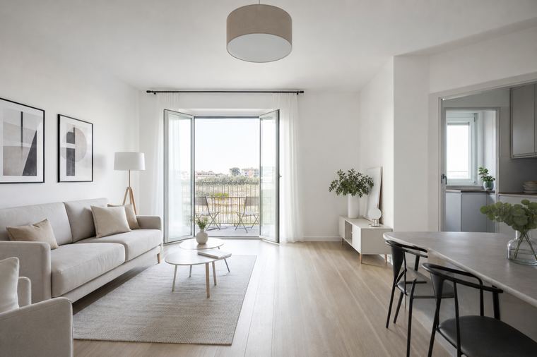 Zona pranzo di un trilocale moderno con tavolo, sedie e cucina sullo sfondo